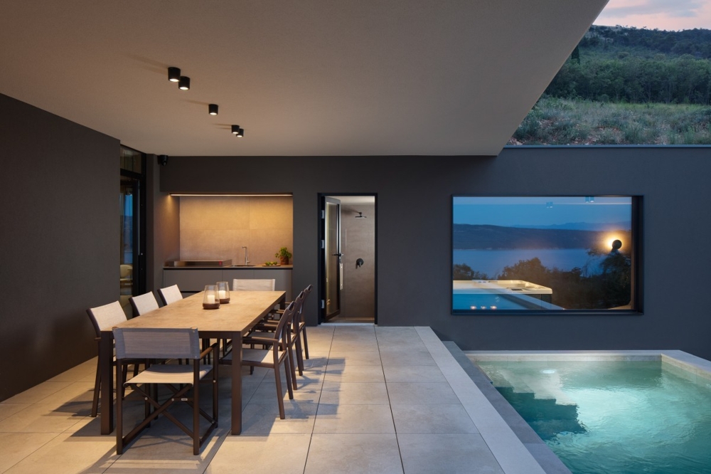 Vonkajší priestor s bazénom a krytým jedálenským kútom vo večernej atmosfére