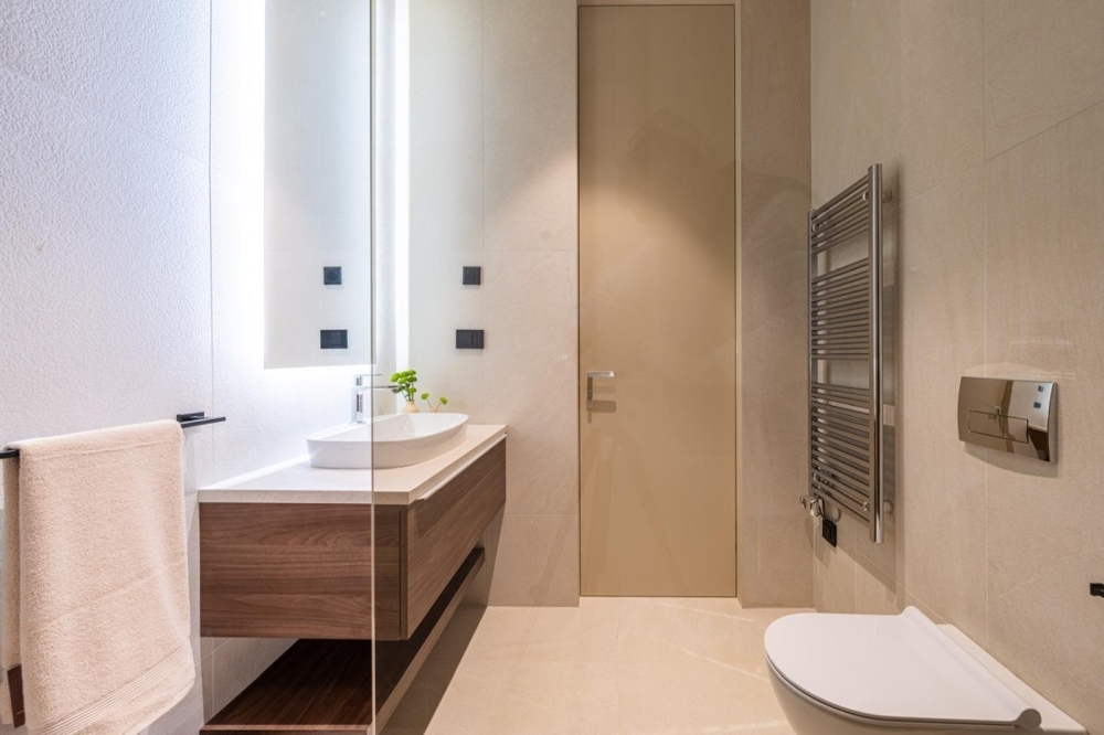 Svetlá kúpeľňa s umývadlom a radiátorom na uteráky