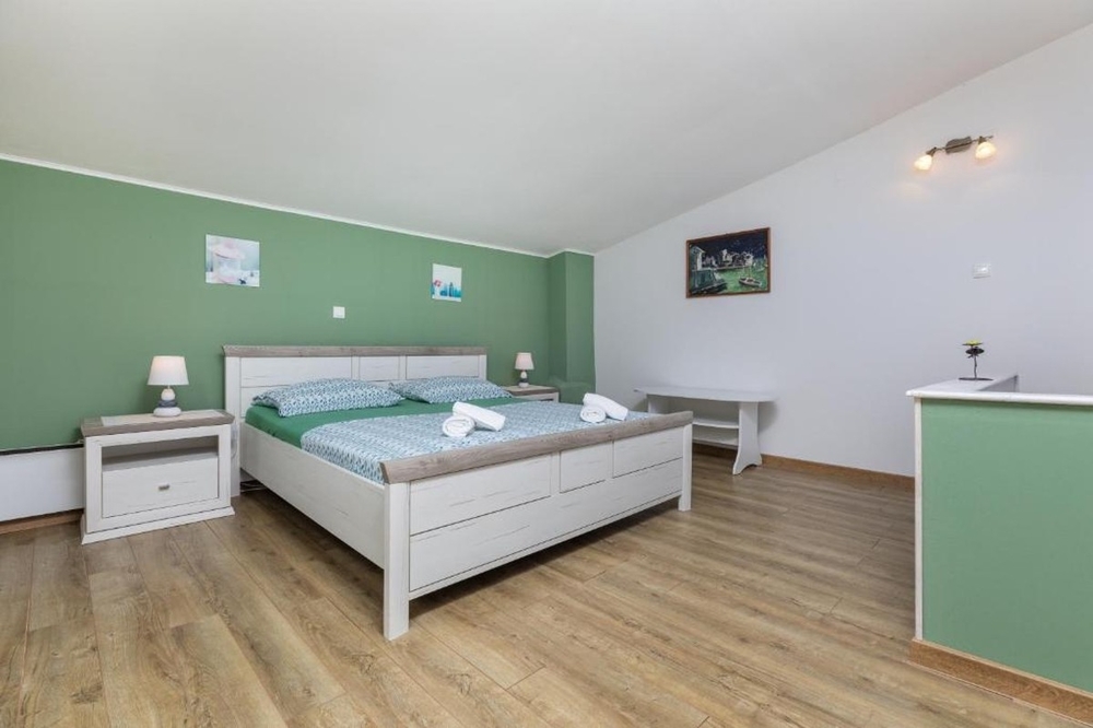 Spálňa s manželskou posteľou a dizajnom zo svetlého dreva