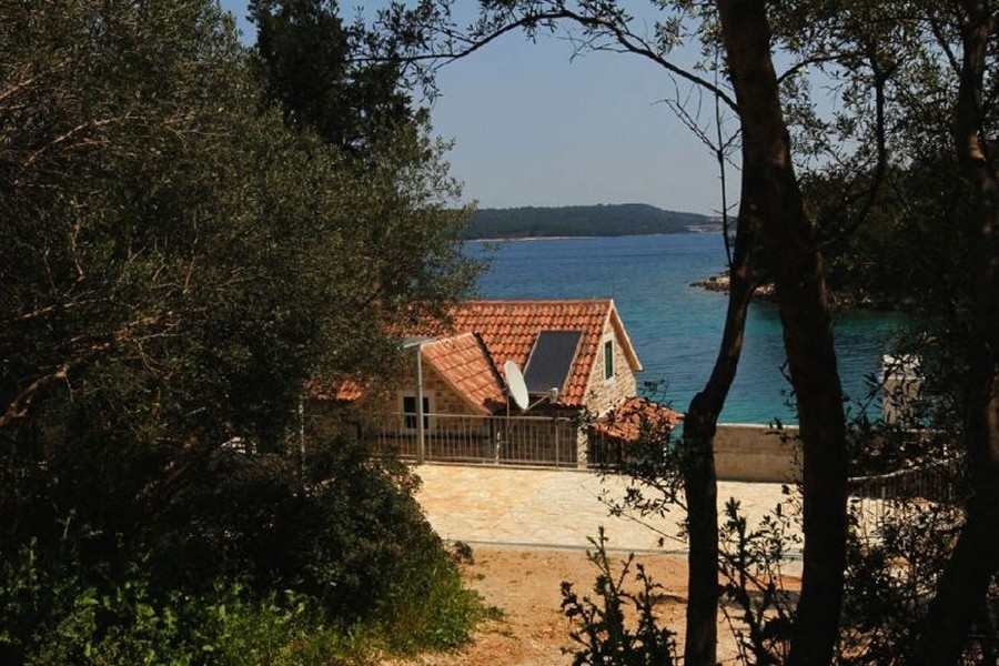 Kamenný dom s výhľadom na more medzi stromami