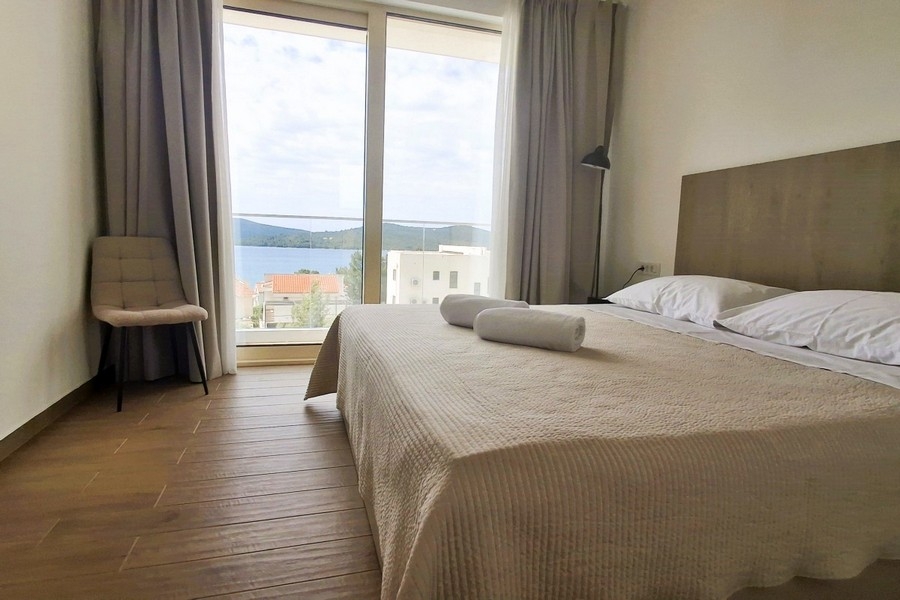Spálňa s veľkým oknom a výhľadom na more