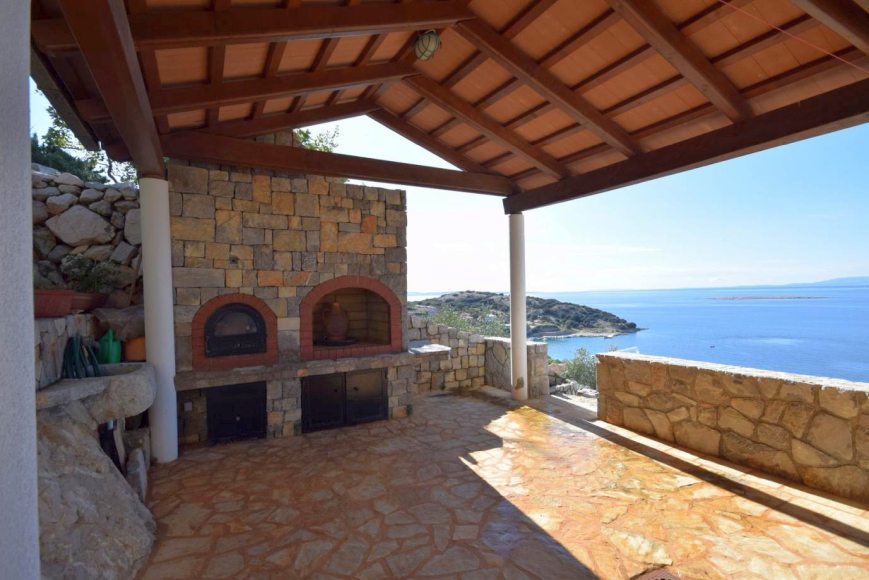 Veľká terasa s výhľadom na more a kamennými pecami.