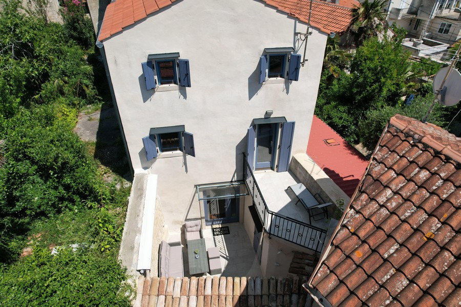 Pohľad zhora na terasu a balkón kamenného domu v Krku