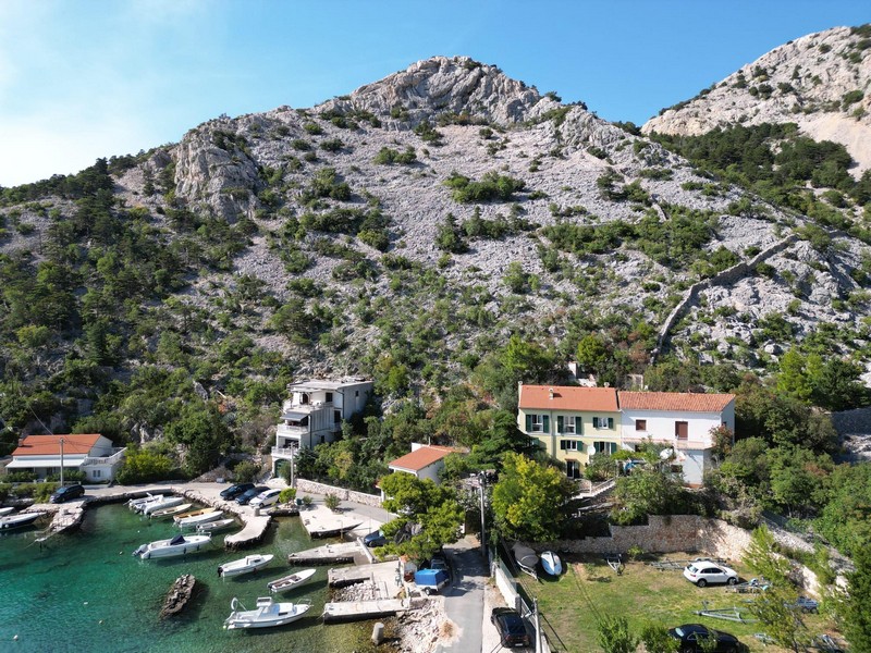 Zátoka s čistou vodou a pohorie Velebit zhora