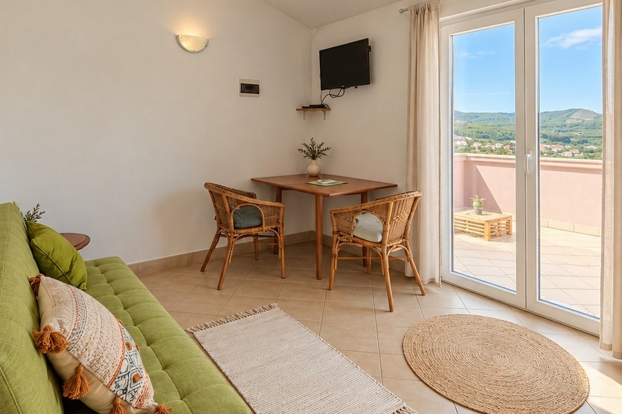 Obývacia izba apartmánu s pohovkou a dverami na terasu