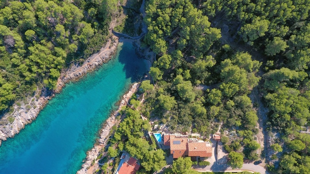 Letecký pohľad na záliv s domom v borovicovom lese