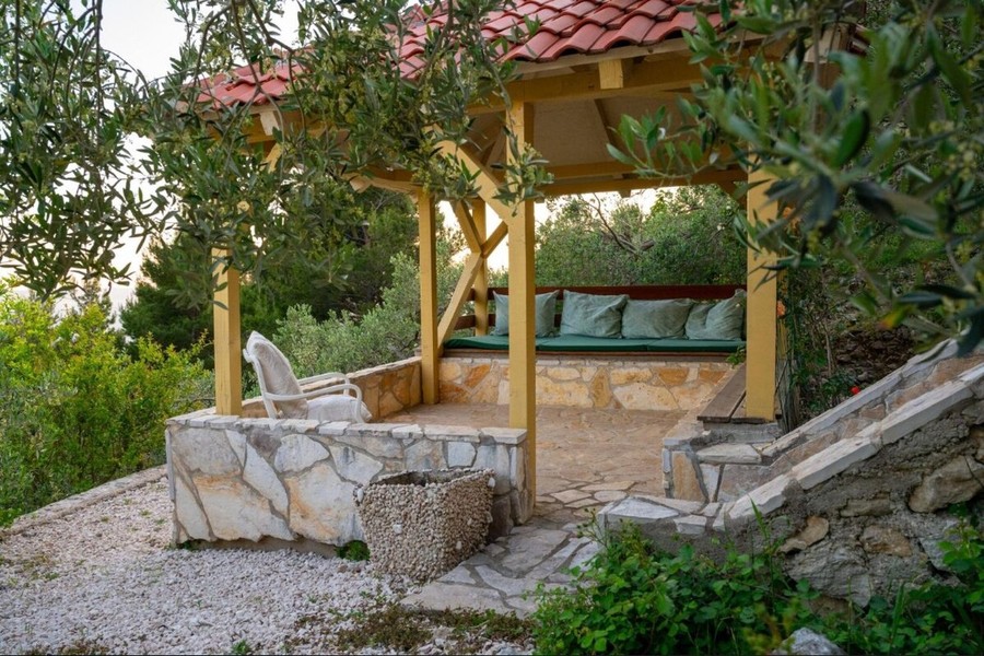 Pergola s lavičkou medzi olivovníkmi