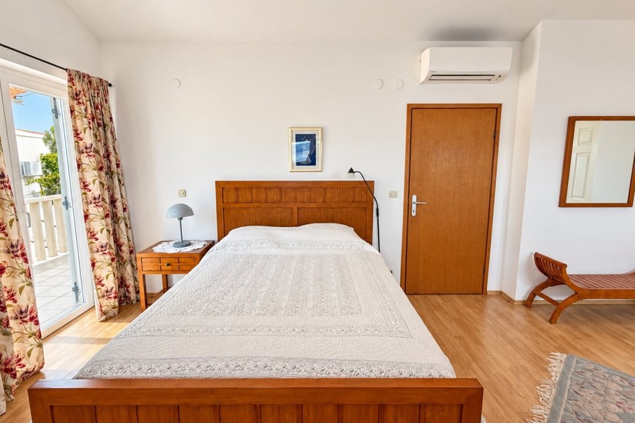 Spálňa s drevenou posteľou a klimatizáciou